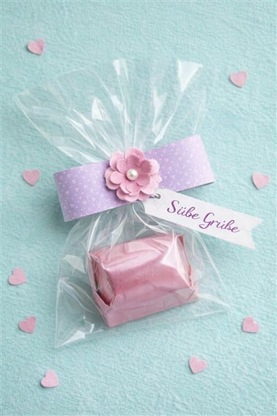 Einzelne Praline verpacken mit Zellophantütchen und Papierbanderolle
